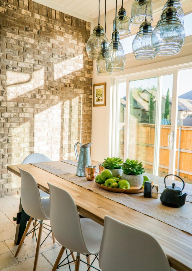 pexels photo 1080696 1080696 Sunlit dining room with contemporary decor and a rustic brick wall, featuring stylish lighting and a wooden table.